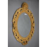 A carved wooden mirror with bevelled glass. 112 cm high.