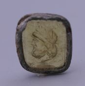 An antique seal carved as a male bust. 1.3 x 1.5 cm overall.