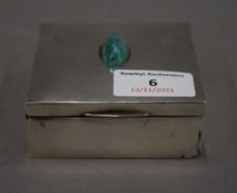 A silver cigarette box with a jade mount. 8 cm wide.