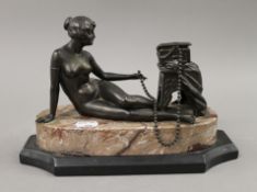 A patinated model of a nude girl mounted on a marble plinth base. 27 cm long.