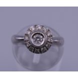 An unmarked white gold diamond cluster ring. Ring size J/K. 4.3 grammes total weight.