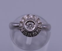 An unmarked white gold diamond cluster ring. Ring size J/K. 4.3 grammes total weight.