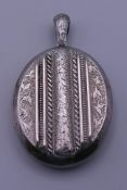 A Victorian unmarked white metal silver double photo locket with embossed front. 7 cm high. 29.