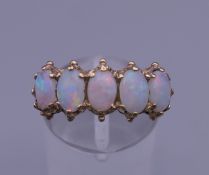 A 9 ct gold five stone opal ring. Ring size P. 3.5 grammes total weight.