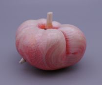 A late 19th/early 20th century carved and stained ivory model of an apple with a maggot. 6 cm wide.