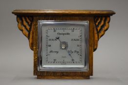 An early 20th century hanging barometer with Art Deco light oak case marked Cox and Sons Great
