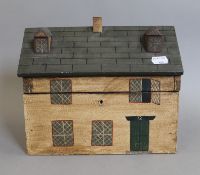 A wooden tea caddy in the form of a house. 26 cm wide.