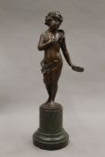 A 19th century patinated bronze model of a putto with a tambourine, the base indistinctly signed,