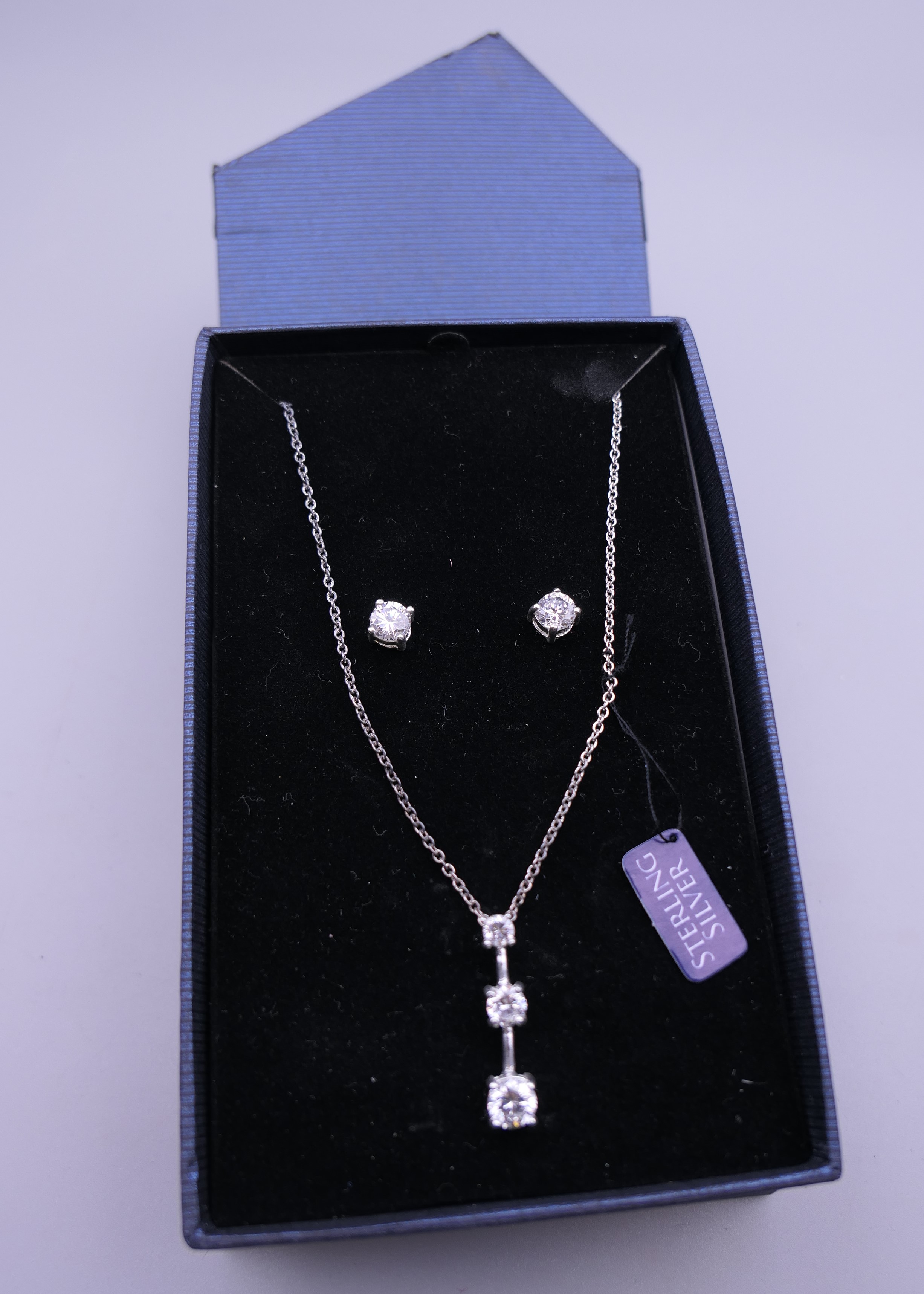 A boxed silver dress pendant on chain and matching earrings. The pendant 2.5 cm high.