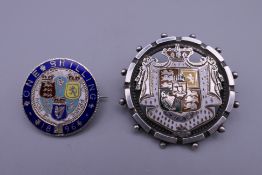Two silver and enamel coin brooches.