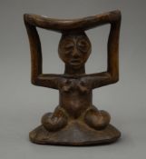 An African Congo region carved wooden head rest supported by a squatting female. 19.5 cm high.