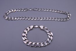 A silver curb link necklace and a matching bracelet. The former 48 cm long. 185.5 grammes.