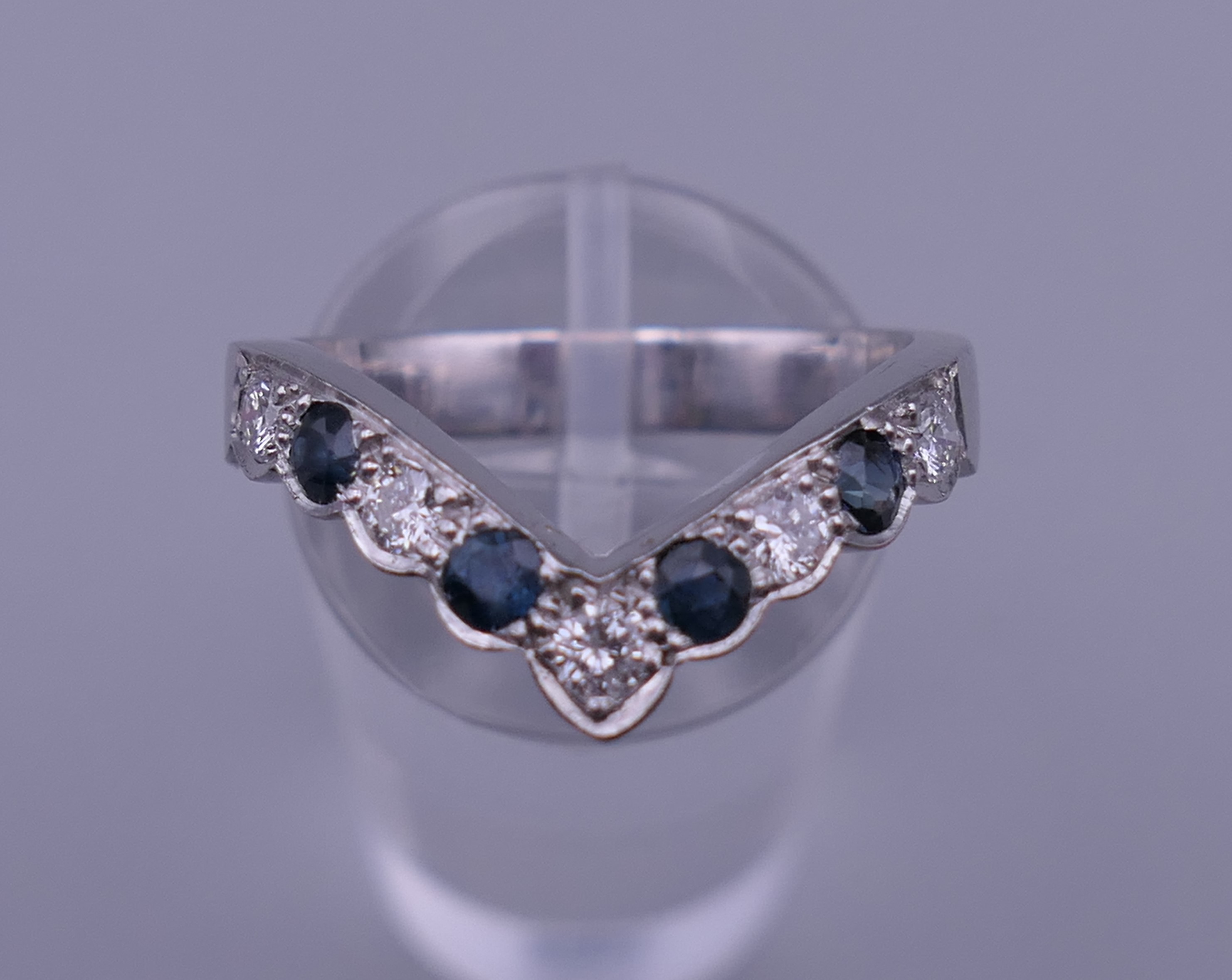 An 18 ct white gold, diamond and sapphire wishbone ring. Ring size Q. 5.7 grammes total weight.