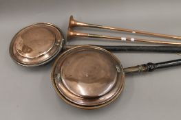 Two copper coaching horns and two warming pans. The horns 80 cm long.