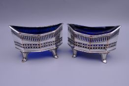 A pair of old Sheffield plate salts with blue liners. 9 cm wide.