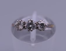 An 18 ct gold three stone diamond ring. Ring size H. 2.2 grammes total weight.