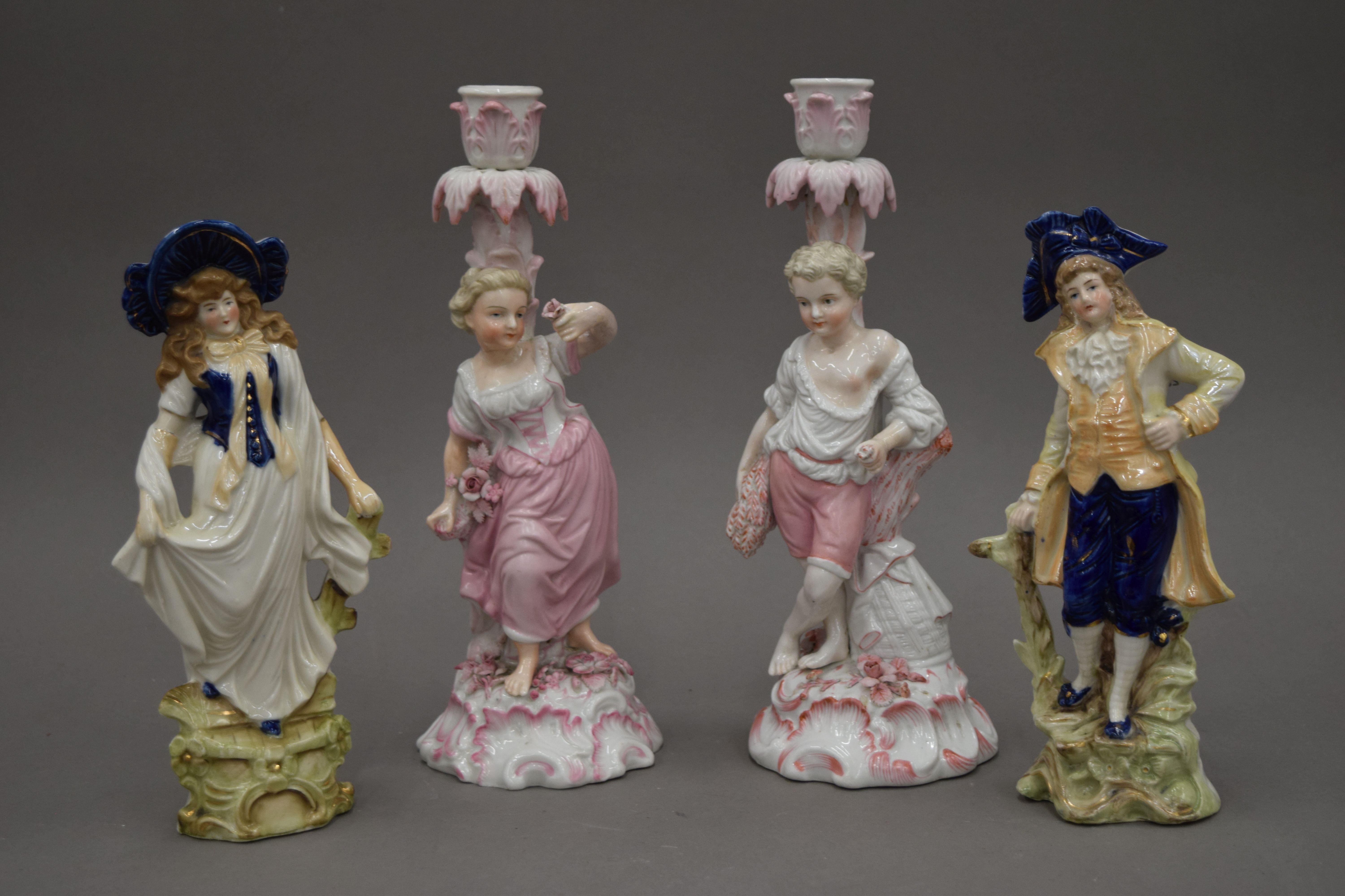 A pair of Continental porcelain figures together with a pair of 19th century candlesticks of
