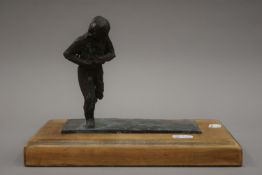 An abstract bronze model of a running man, initialled R.B, mounted on a wooden plinth base.