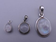 Three silver and moonstone pendants. The largest 2.5 cm high.