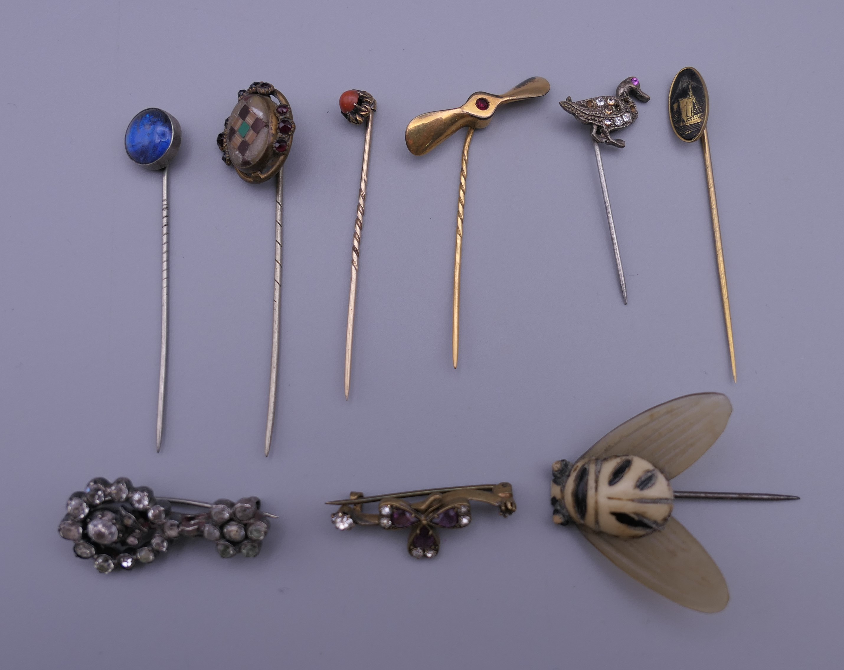 A collection of stick pins and brooches.
