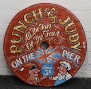 A large wooden painted Punch and Judy sign. 85 cm diameter.