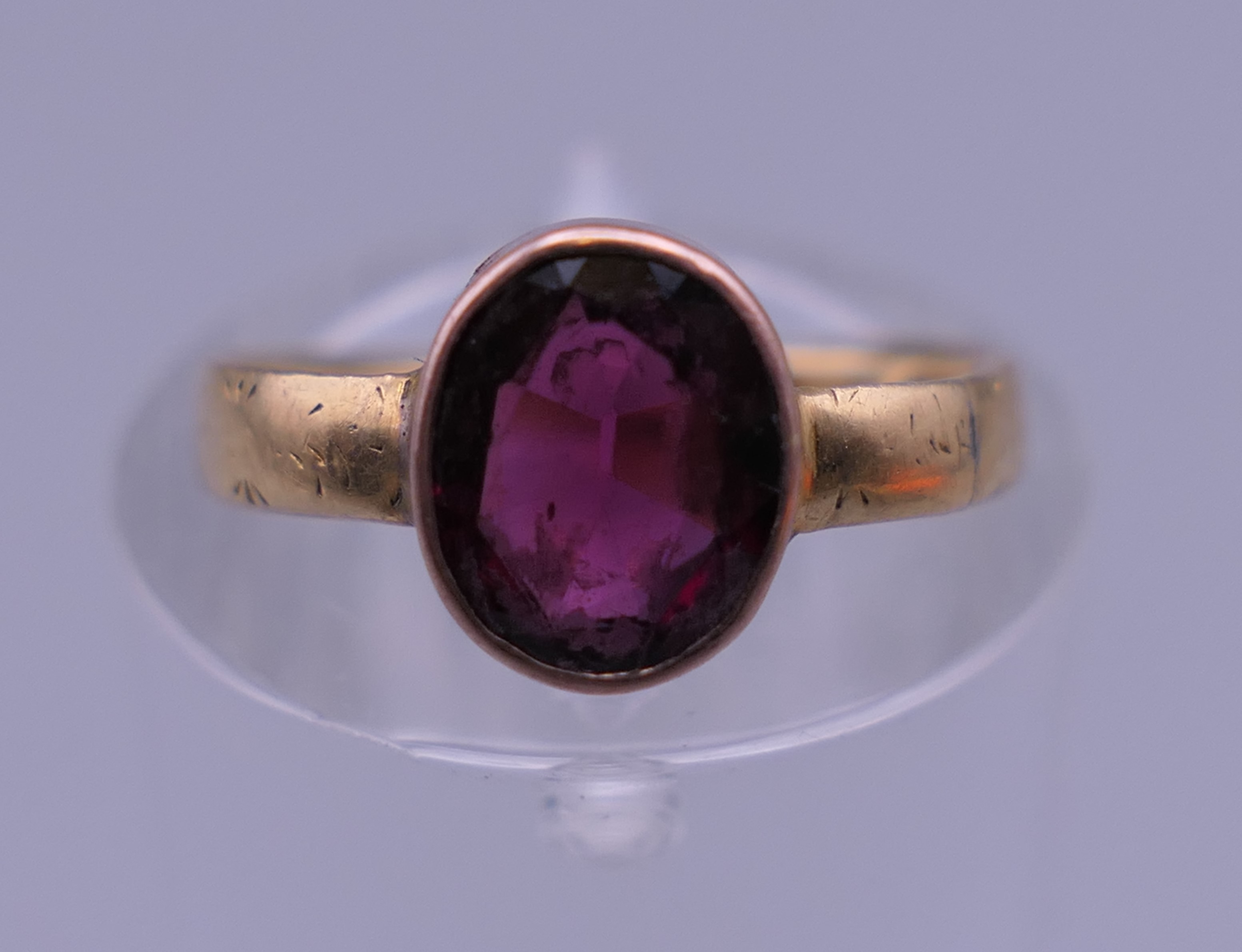 A garnet set gold ring, possibly 9 ct and 18 ct gold. Ring size F. 1.9 grammes total weight.