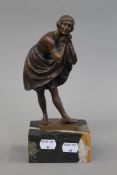 A bronze figure of a girl lifting her skirt on a marble base. 23.5 cm high.