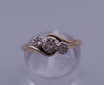 A 9 ct gold and platinum three stone synthetic white sapphire ring. Ring size N/O. 1.