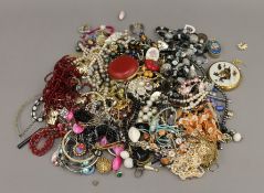 A tin of various costume jewellery.