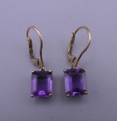 A pair of 9 ct gold amethyst earrings. Each 1 cm high. 3.6 grammes total weight.