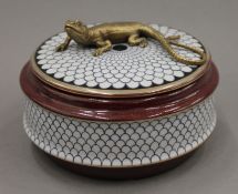 A porcelain box surmounted with a lizard. 14 cm diameter.