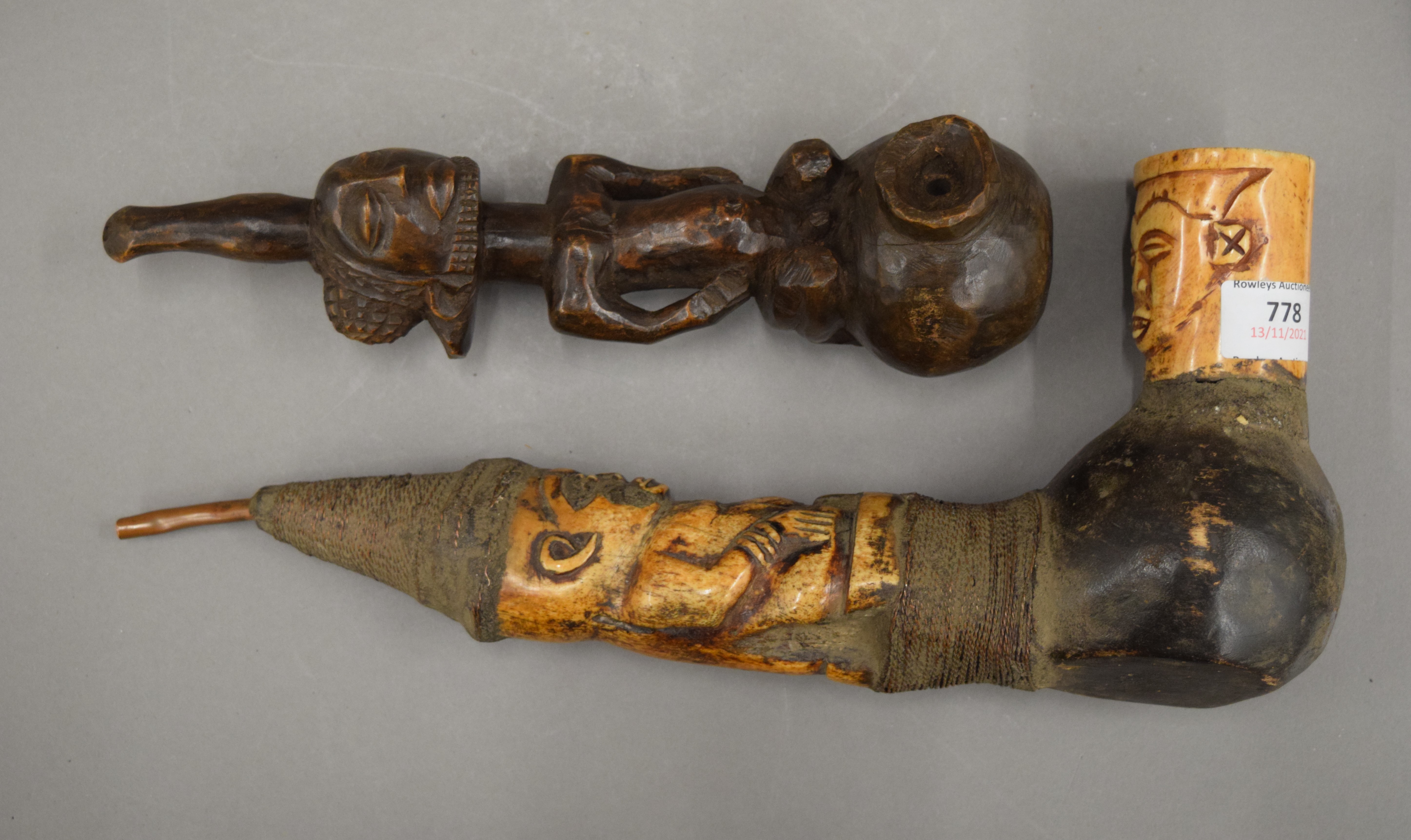 Two African carved bone and wooden pipes. The largest 34.5 cm long.