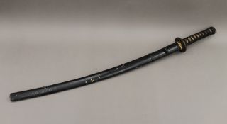 A Japanese katana in scabbard. 95 cm long.