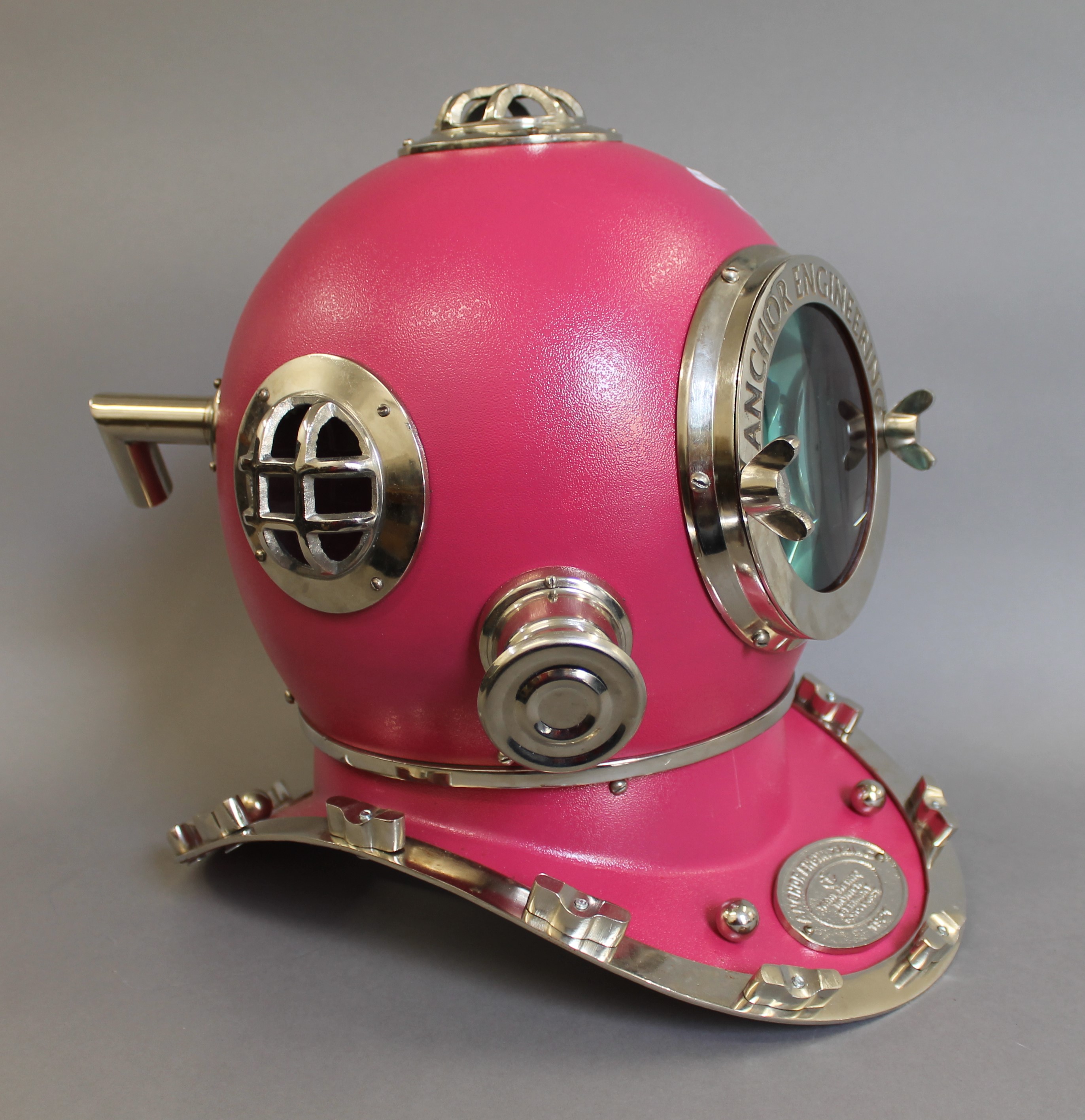 A pink model of a diver's helmet. 43 cm high.