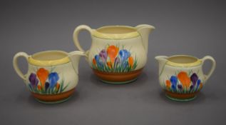 Three Clarice Cliff Crocus pattern jugs. The largest 12.5 cm high.