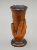 A late 19th century Pitcairn Islands wood carving of a hand holding a vase,