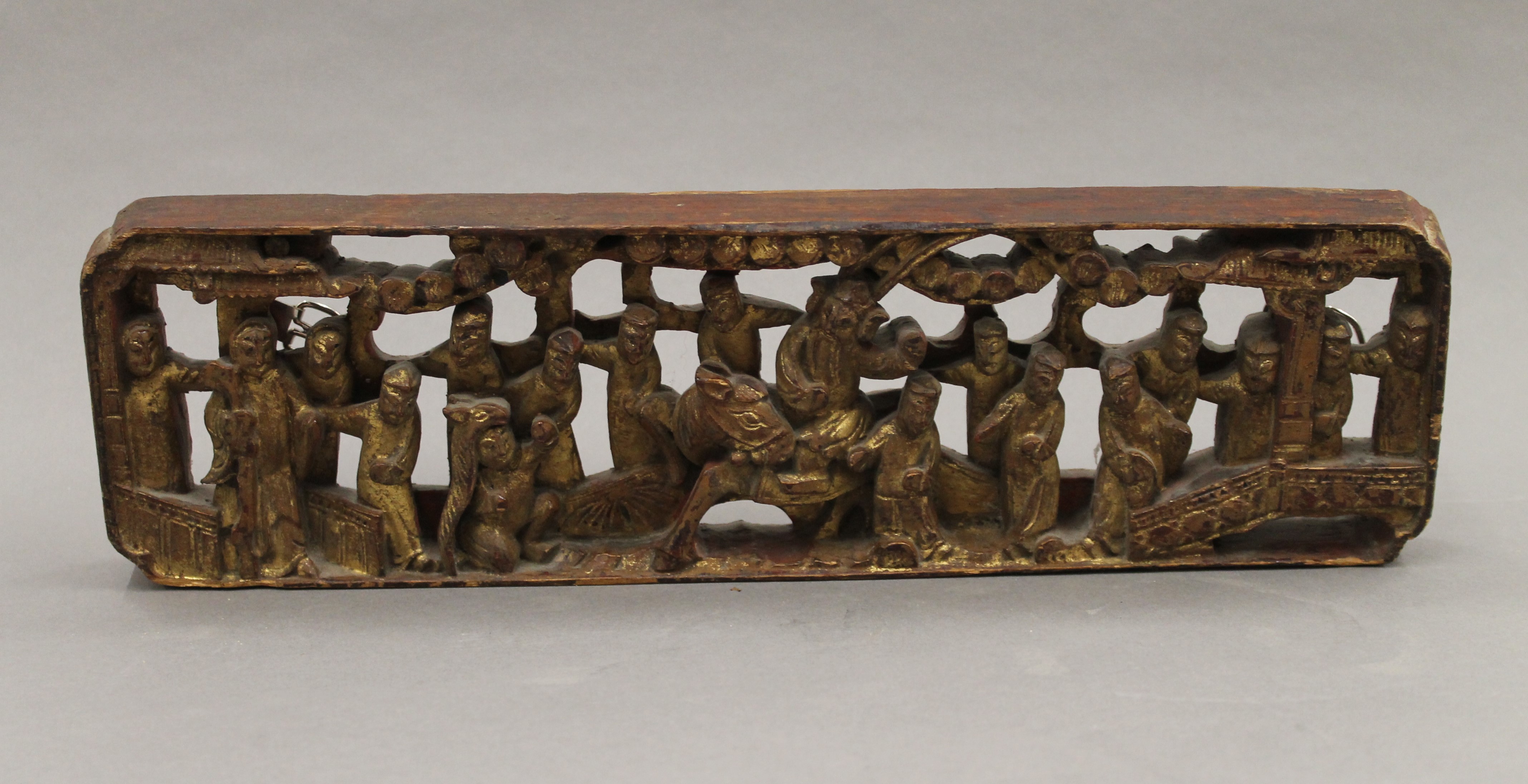 A Chinese gilt heightened carved wooden rectangular plaque. 34 cm long.