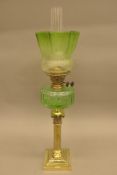 A Victorian brass Corinthian column oil lamp with green glass reservoir and shade. 76 cm high.