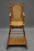 An early 20th century oak barley twist bergere child's high chair. 105 cm high.