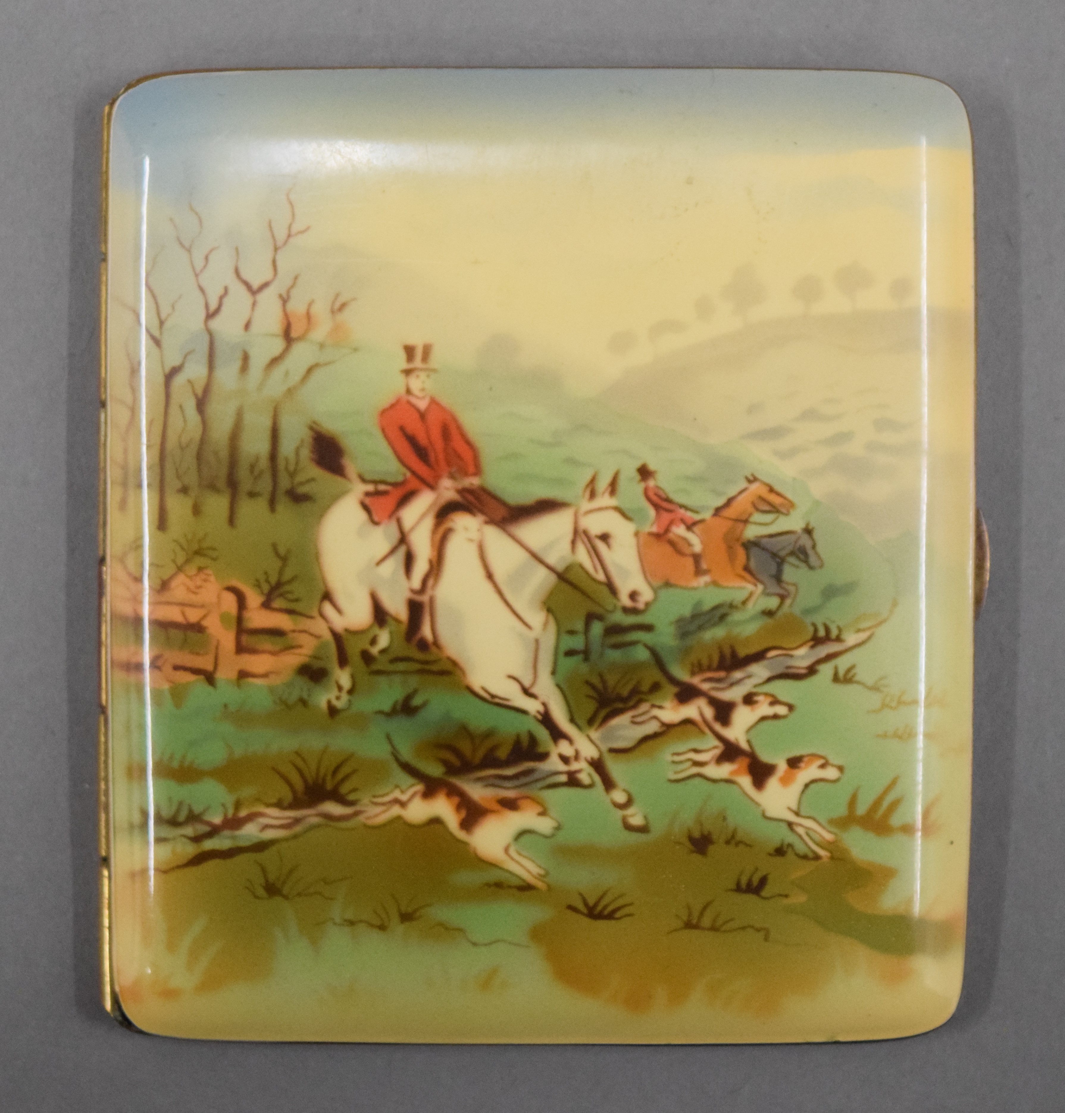 A vintage cigarette case decorated with a fox hunting scene. 8 cm wide.