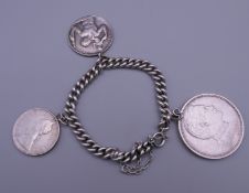 A silver bracelet set with various coins. 81.9 grammes total weight.