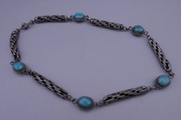 A silver and turquoise necklace. 55.5 cm long.