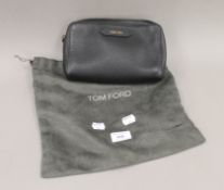 A Tom Ford black leather clutch bag and cover. 22 cm wide.