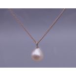 A pearl pendant on a 9 ct gold chain. The pearl approximately 9 mm high.