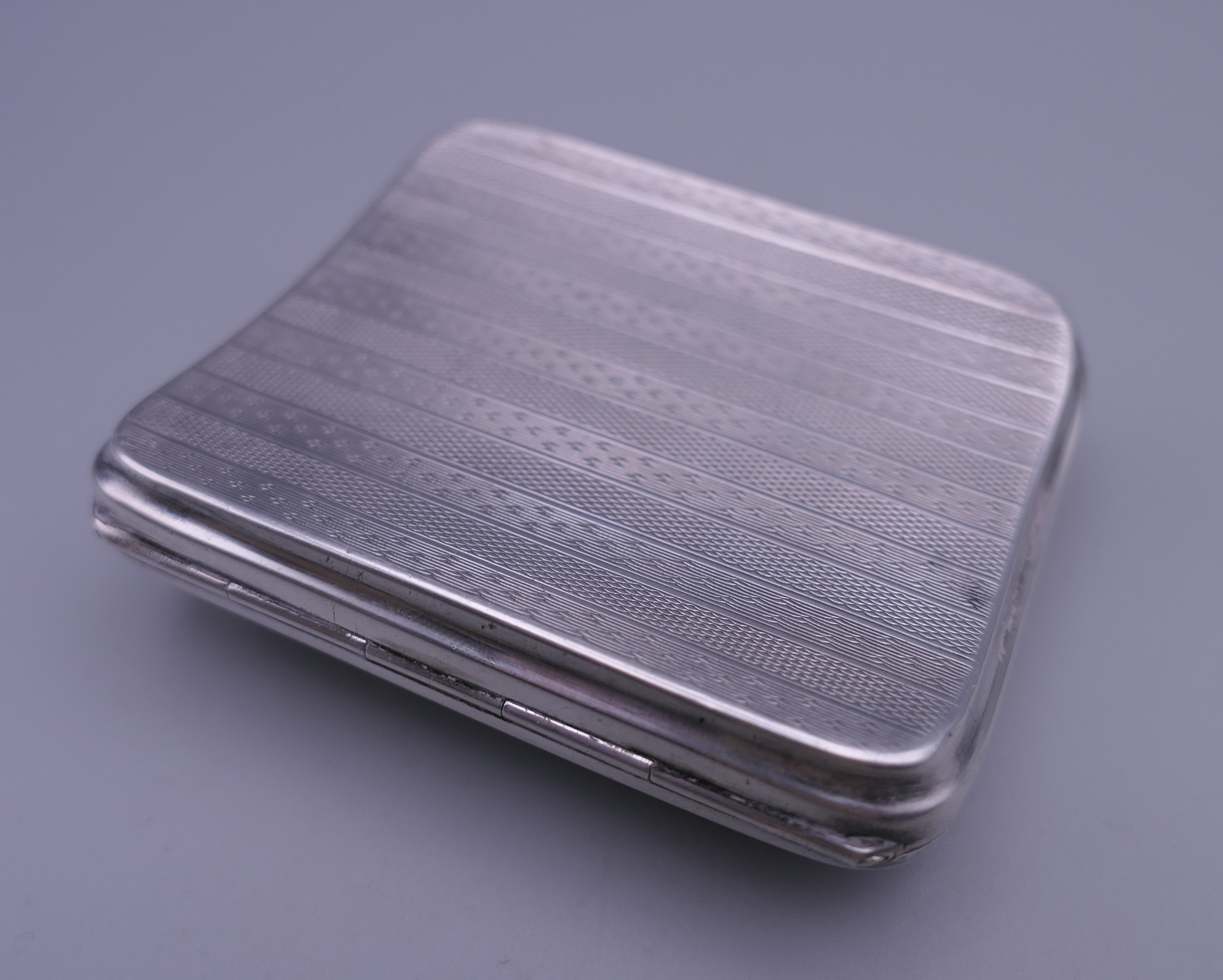 A silver cigarette case decorated with a scantily clad lady. 7 cm wide. - Image 2 of 9