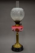 A Victorian oil lamp with etched glass shade. 67 cm high overall.