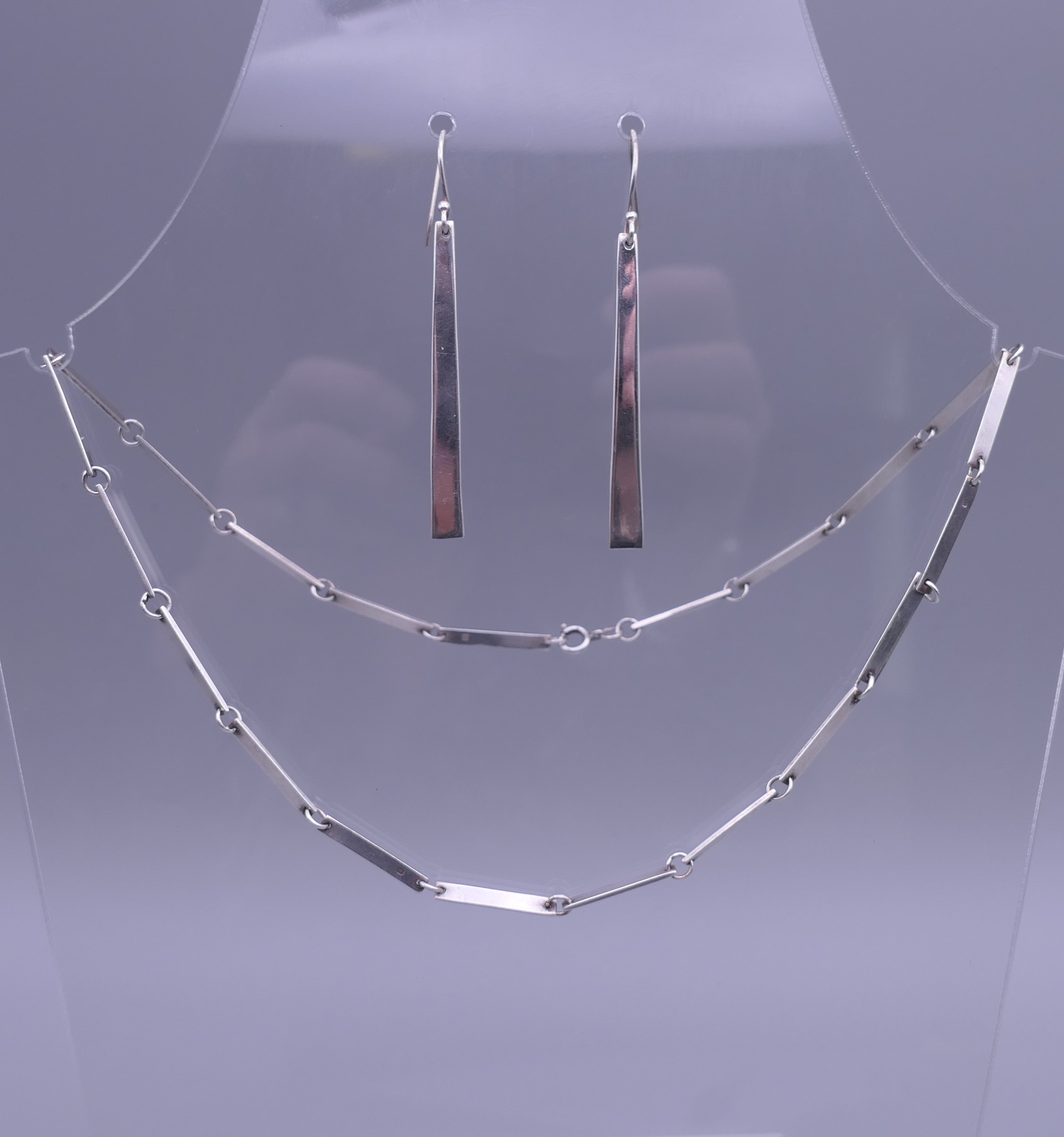 A Contemporary silver necklace and earrings en-suite. The necklace 46 cm long.