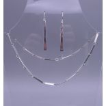 A Contemporary silver necklace and earrings en-suite. The necklace 46 cm long.