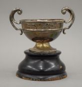 A silver twin handled trophy cup on stand. 15 cm wide. 145.7 grammes.