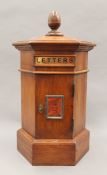 A wooden post box. 46 cm high.